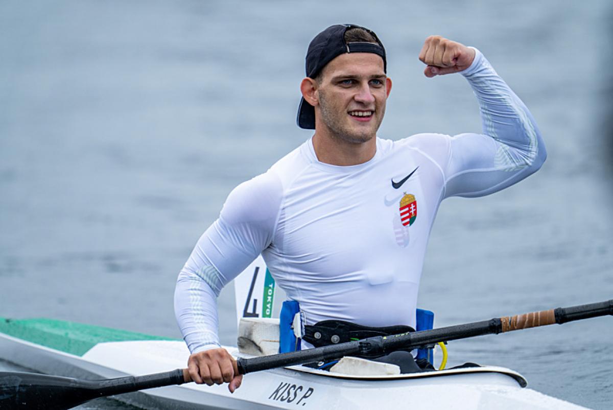 Male Para canoeist Peter Pal Kiss flexes his bicep in celebration